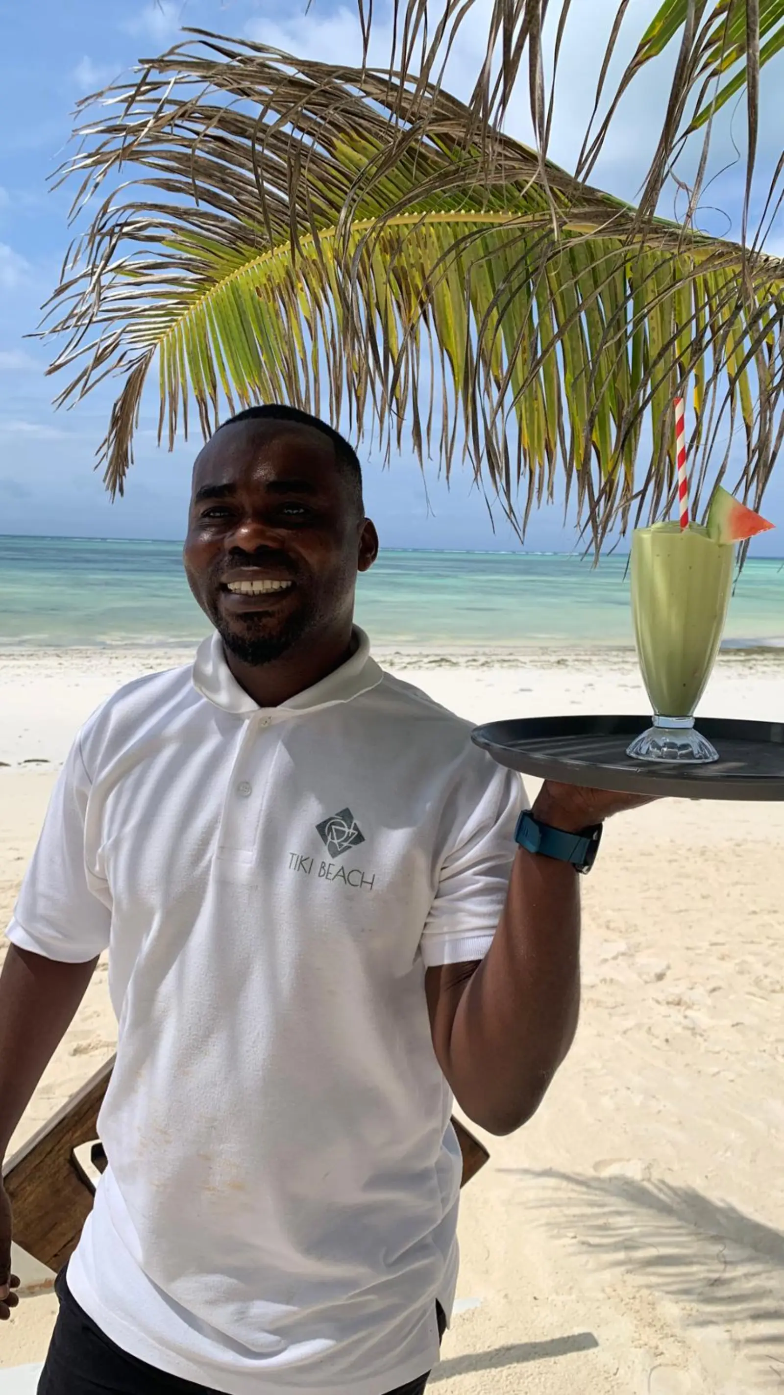 Tiki Beach team member serving a tropical drink